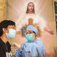 ȘTIINȚĂ ȘI CREDINȚĂ Un doctor  administrează o doză de vaccin AstraZeneca la Biserica Catolică a Duhului Sfânt din Parohia Babakan din zona Canggu din Bali, Indonezia - Foto: Getty Images