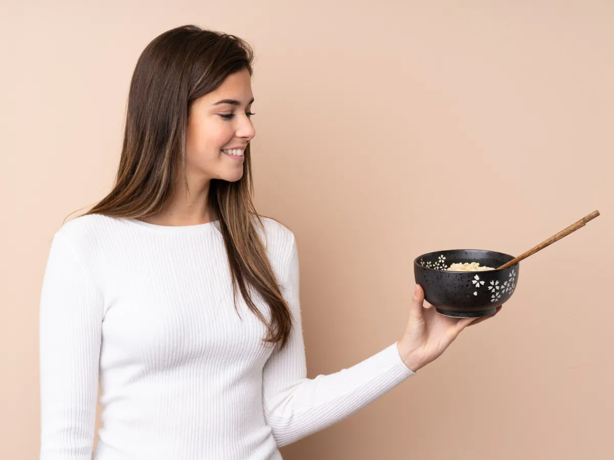 Femeie care ține în mână un bol cu orez - Foto: Freepik (Imagine cu rol ilustrativ)