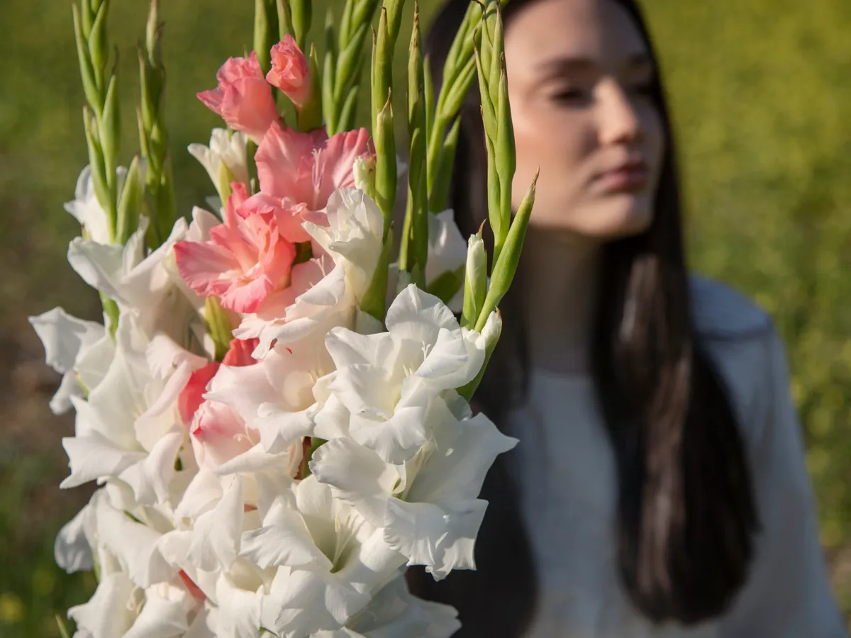 Persoană cu gladiole - Foto: Magnific.com (Imagine cu rol ilustrativ)