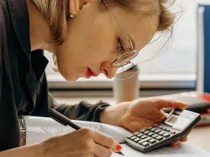 Femeie făcând calcule complicate - Foto: Pexels/Mikhail Nilov