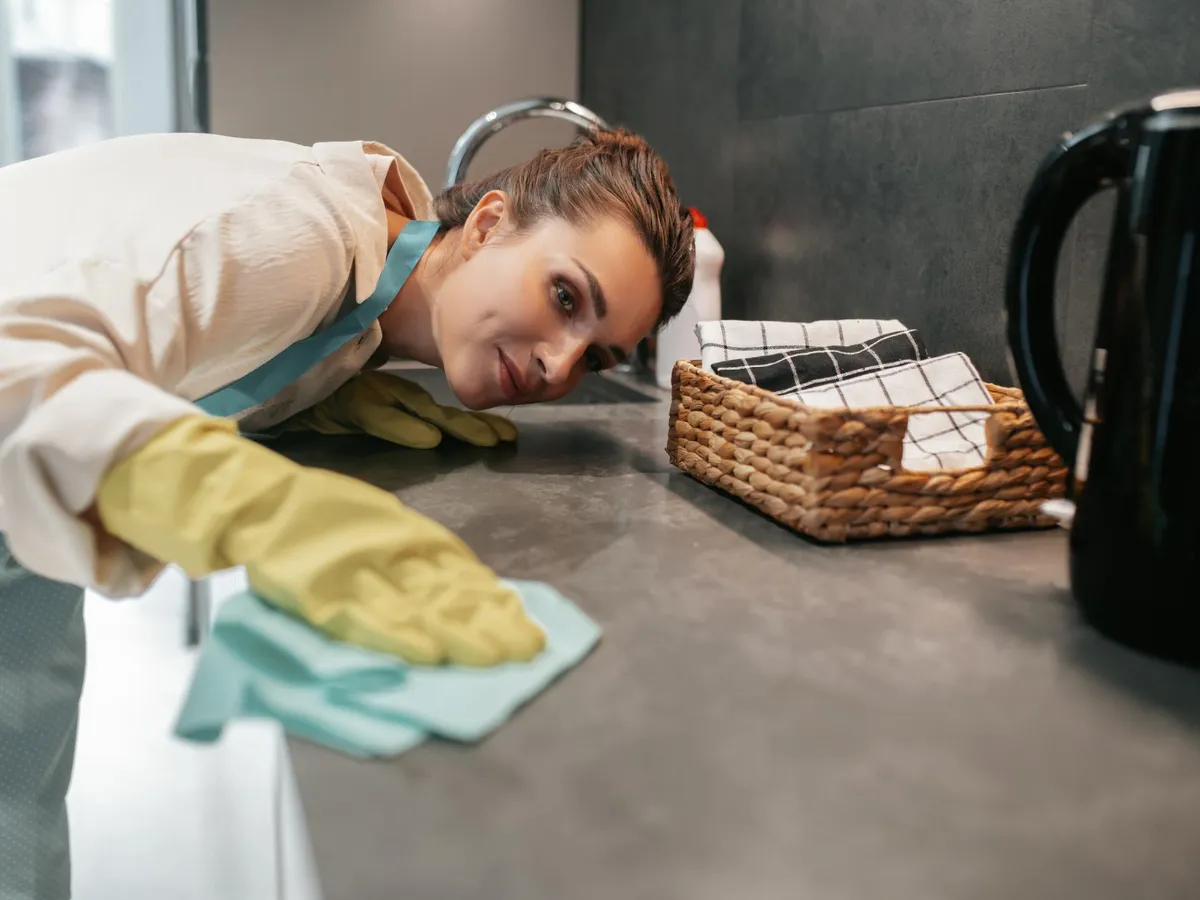 Femeie care șterge blatul de la bucătărie - Foto: Freepik (Imagine cu rol ilustrativ)