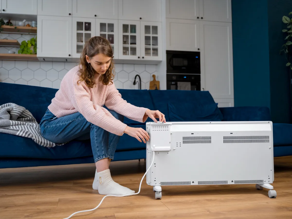 Femeie care deschide caloriferul - Foto: Freepik (rol ilustrativ)