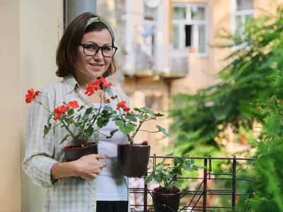 Femeie cu flori în balcon - Foto: Magnific.com (Imagine cu rol ilustrativ)