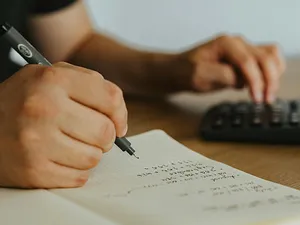 Persoană făcând calcule matematice - Foto: Pexels/olia danilevich