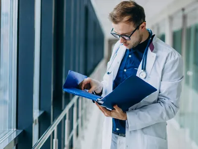Un medic citește un raport  - Foto: Freepik