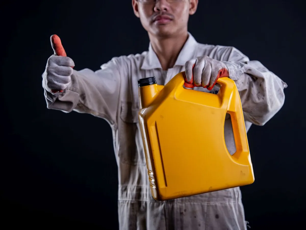 Mecanic ţinând în mână un bidon cu ulei - Foto: Freepik/jcomp