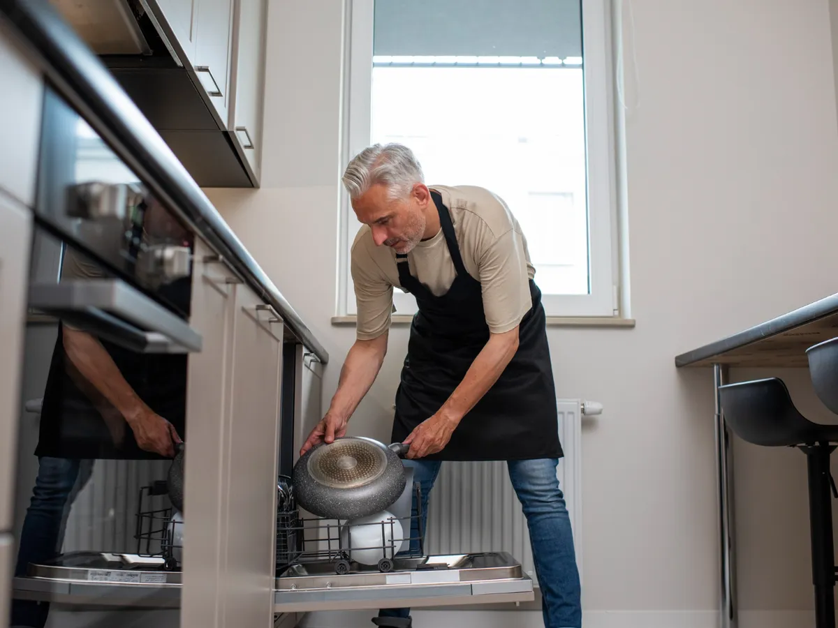 Bărbat care încarcă vasele în mașină - Foto: Freepik (Imagine cu rol ilustrativ)