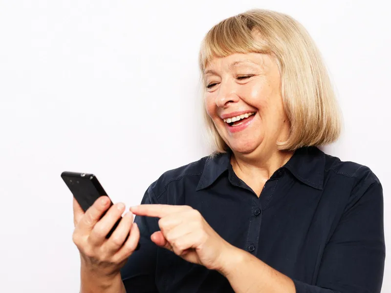 Pensionară verificând pe telefon dacă i-a intrat pensia - Foto: Freepik