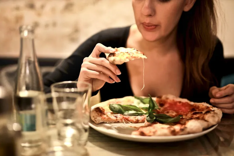 Femeie mancand pizza