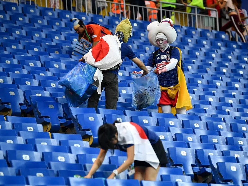 Suporterii japonezi strâng gunoiul de pe stadion după partida dintre Japonia și Germania - Foto: Profimedia