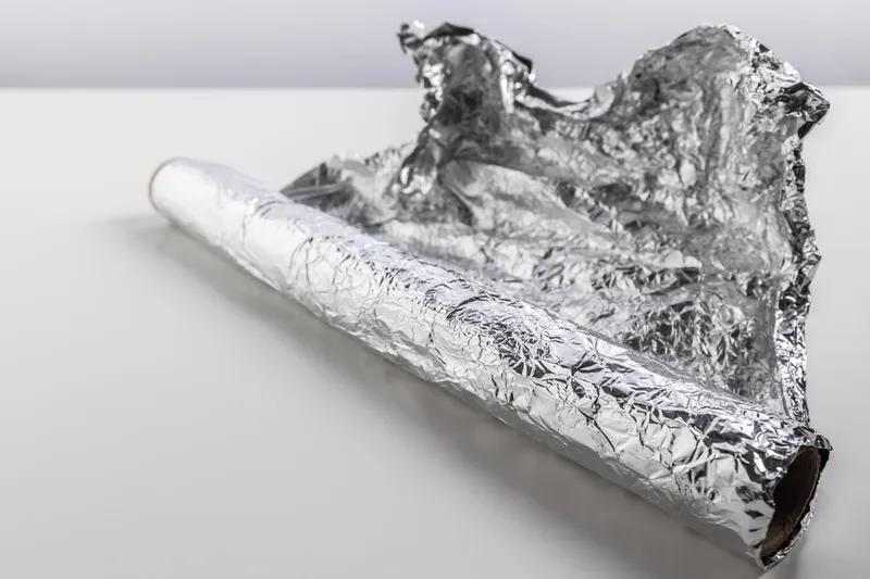 Rolă de folie de aluminiu izolată pe fundal alb - Foto: Magnific.com (Imagine cu rol ilustrativ)