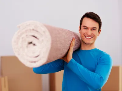 Bărbat fericit care căra un covor - Foto: Magnific.com (Imagine cu rol ilustrativ)