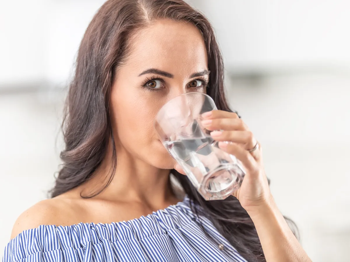 Femeie care bea apă dintr-un pahar  Foto: Freepik (Imagine cu rol ilustrativ)