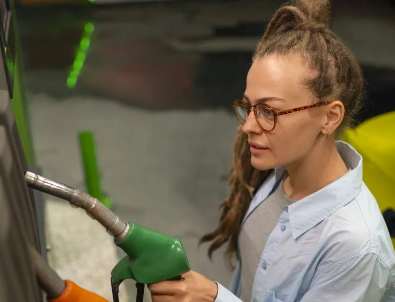 Femeie făc&acirc;nd plinul, la pompa de benzină - Foto: Freepik/CC0