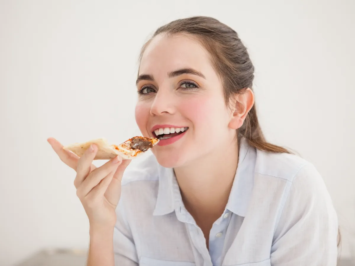Femeie care mănâncă pizza - Foto: Freepik (Imagine cu rol ilustrativ)