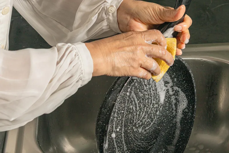 Persoană care spală o tigaie - Foto: Freepik (Imagine cu rol ilustrativ)