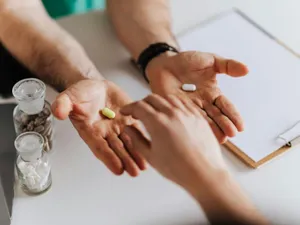 Doctor oferindu-i unui pacient alegerea pastilei potrivite - Foto: Pexels/Karolina Grabowska