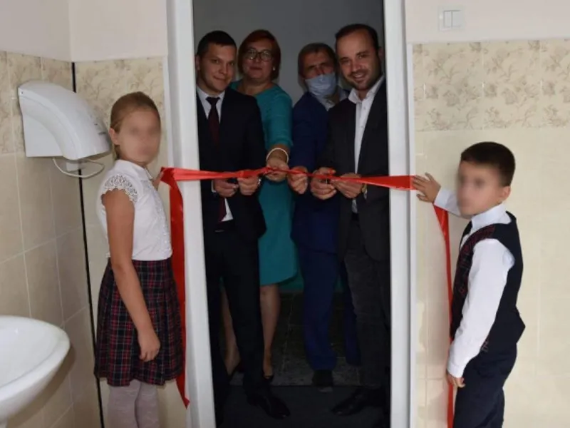 Mai multe oficialități au participat la tăierea unei panglici roșii la inaugurarea unei toalete într-o școală din R. Moldova Foto: agora.md