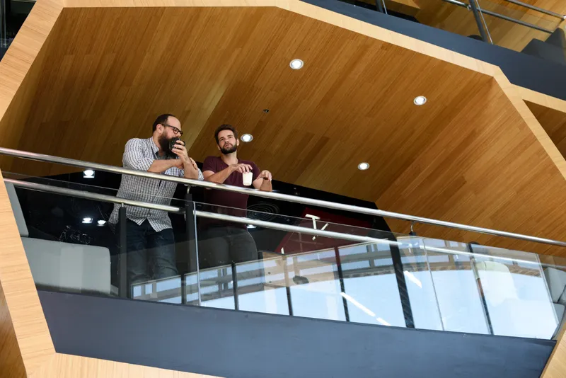 Doi bărbați care stau la balconul unui bloc - Foto: Freepik (rol ilustrativ)