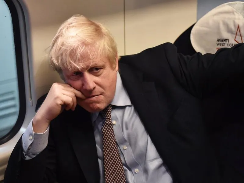 Boris Johnson se agață cu dinții de scaun/ FOTO: The Guardian