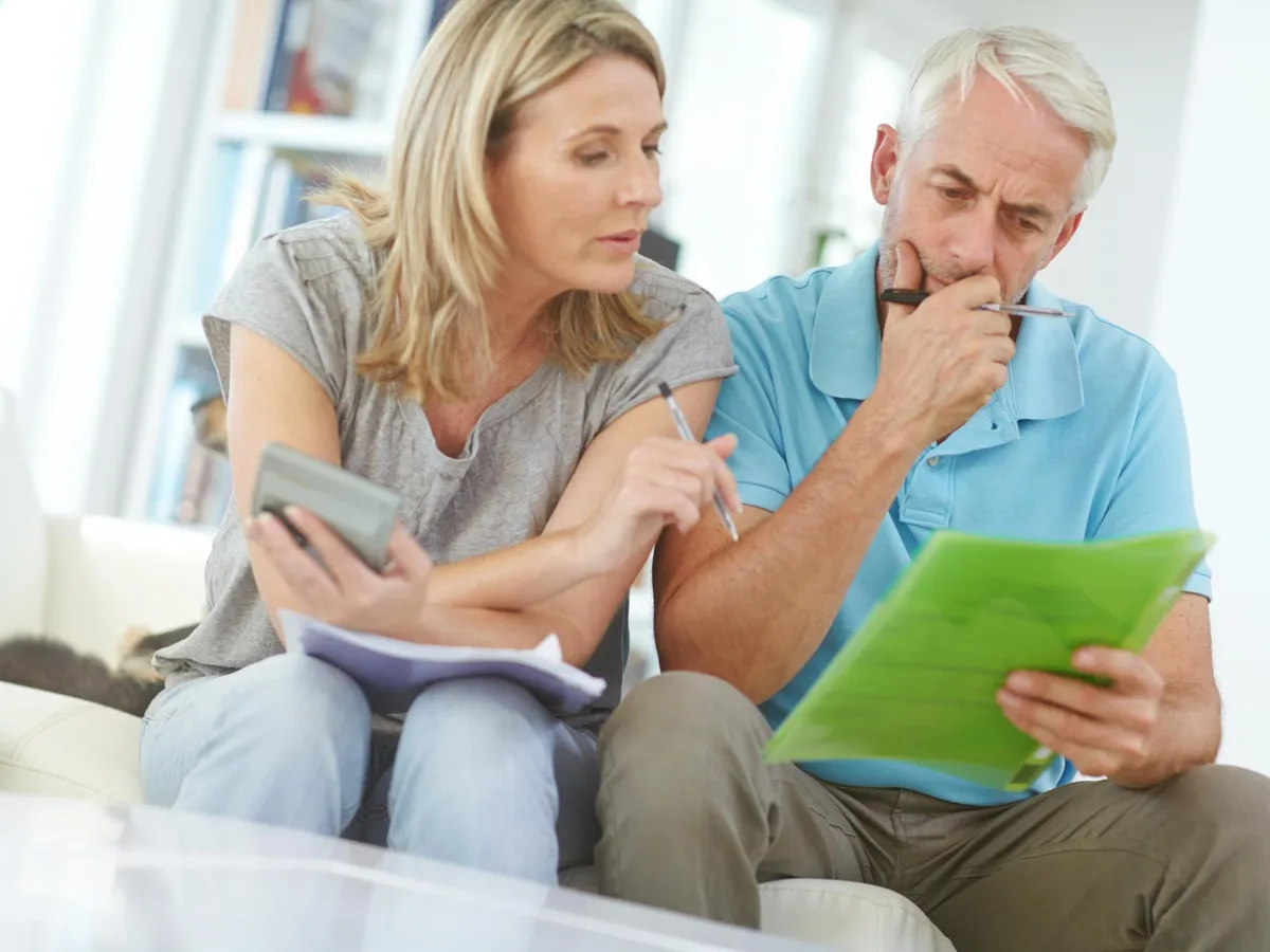 Pensionari citind hârtii la pensie - Foto: Freepik