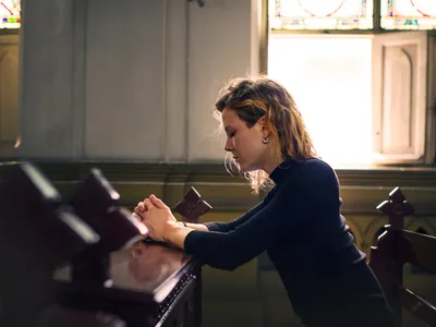 O femeie se roagă în biserică - Foto: freepik (rol ilustrativ)