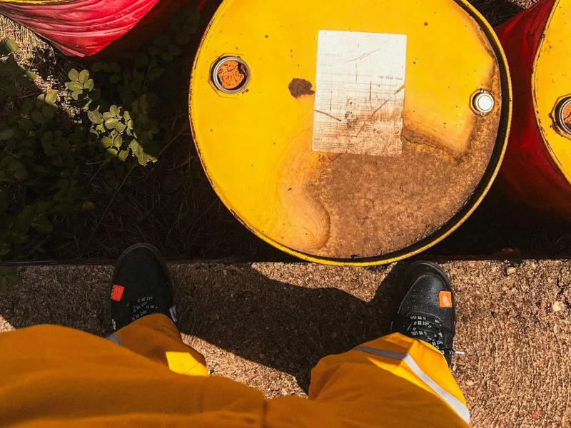 Butoaie cu petrol lângă o persoană care stă în picioare - Foto: Pexels/Biong Abdalla