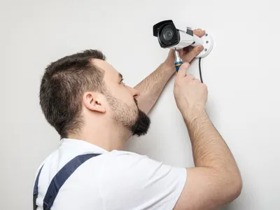 Bărbat care montează o cameră de supraveghere - Foto: Magnific.com (Imagine cu rol ilustrativ)