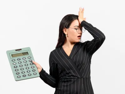 Femeie supărată făcând calcule complicate - Foto: Freepik/KamranAydinov