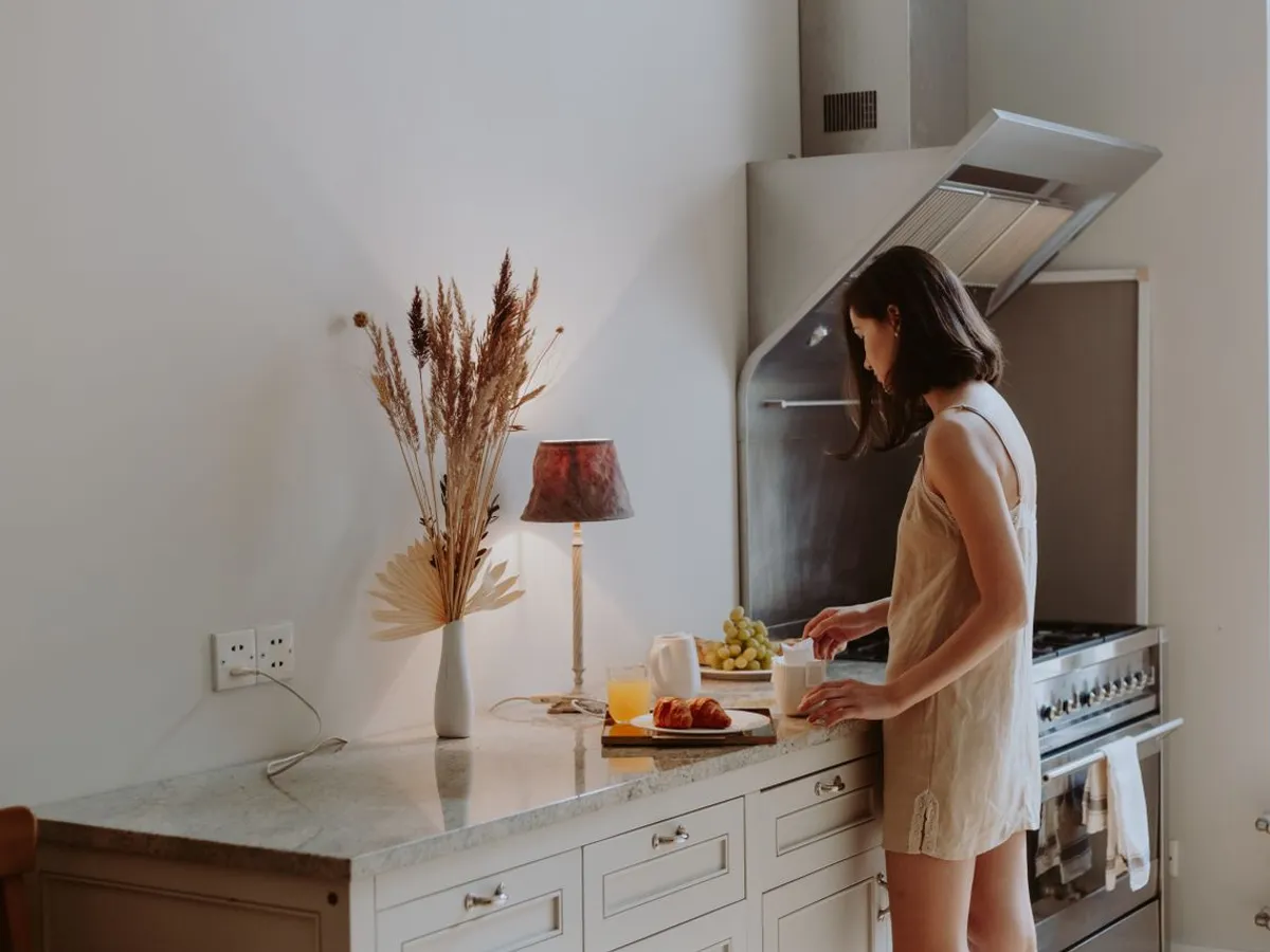 Femeie în bicătărie lângă hotă - Foto: Pexels (Imagine cu rol ilustrativ)