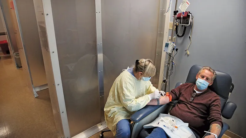 o asistentă se  pregătește să trateze un pacient cu COVID-19 cu un anticorp  monoclonal la  Centrul Medical Tufts din Boston