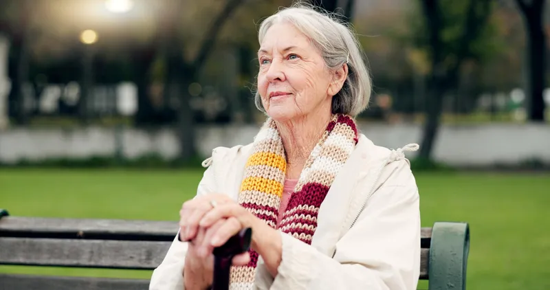 Pensionară pe o bancă în parc - Foto: Freepik