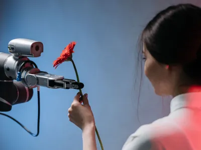 Femeie luând o floare de la un robot - Foto: Pexels/Pavel Danilyuk