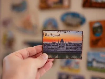 Persoană care ține în mână un magnet de frigider - Foto: Magnific.com (Imagine cu rol ilustrativ)