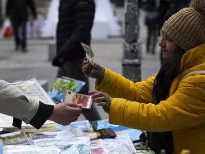 Clienții unei piețe în aer liber din Sofia plătesc cu bancnote euro, odată cu adoptarea oficială a monedei euro, de către Bulgaria - Foto: Profimedia Images