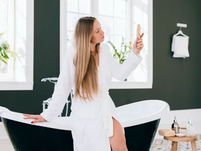 Fată blondă care pozează în baie cu halat de baie - Foto: Magnific.com (Imagine cu rol ilustrativ)