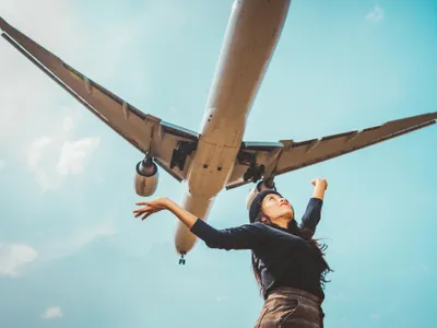 Femeie care are deasupra ei un avion - Foto: Freepik (imagine cu rol ilustrativ)