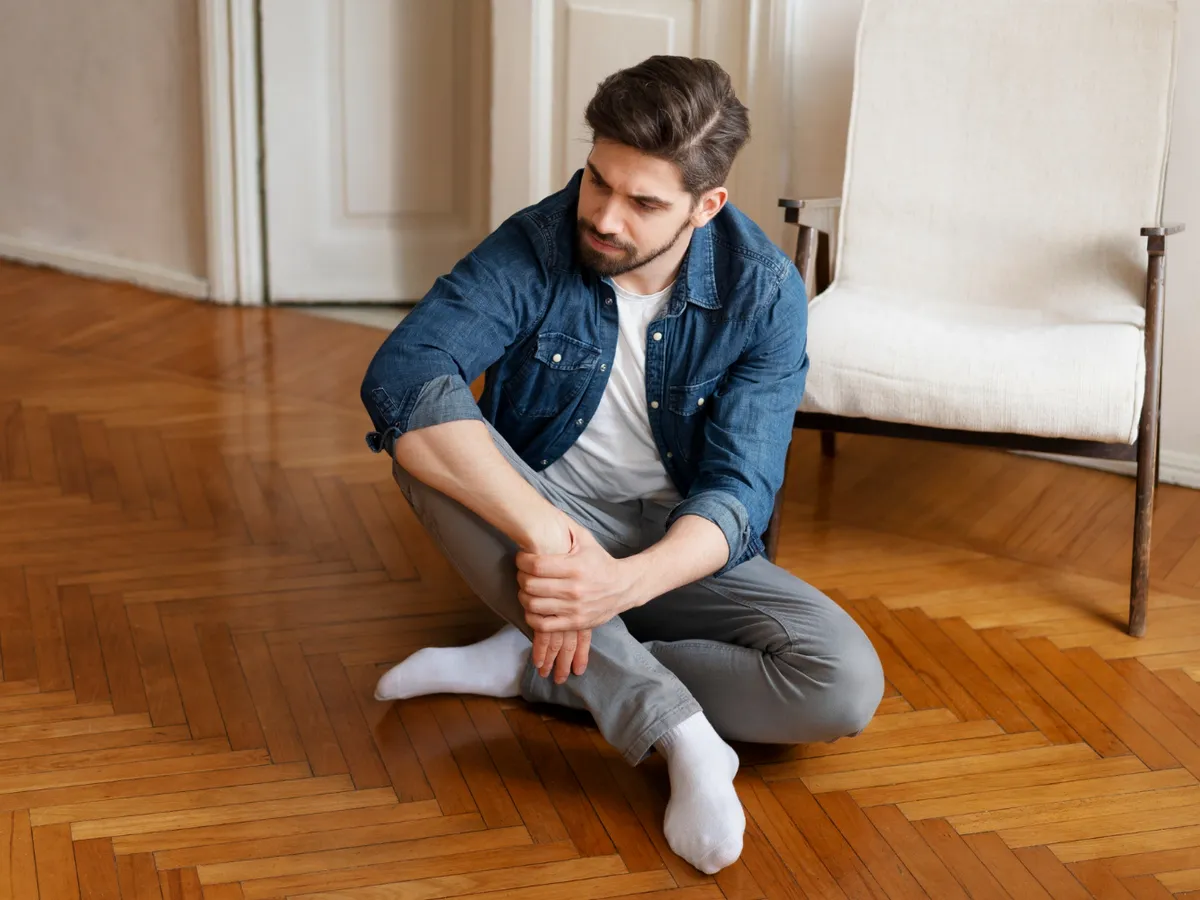 Bărbat stând pe podea - Foto: Magnific.com (Imagine cu rol ilustrativ)