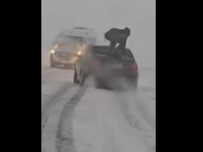 Un român s-a urcat pe un BMW pentru a-i crește „apăsarea” pe zăpadă. Șoferul va fi amendat - Foto: captură video