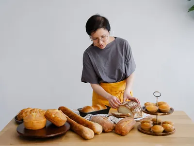Femeie cu diverse tipuri de pâine - Foto: Pexels (cu rol ilustrativ)