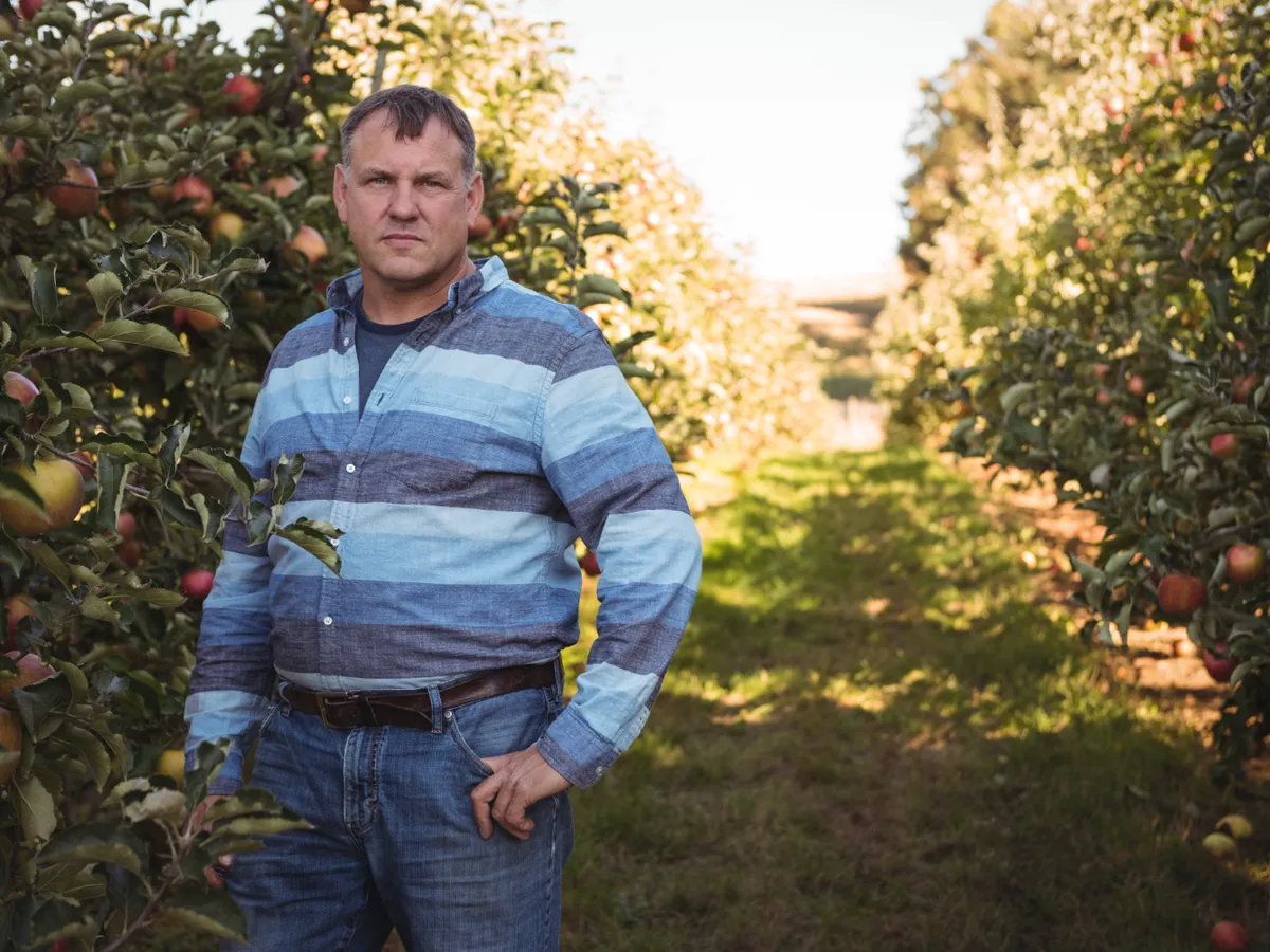 Portretul unui fermier în picioare într-o livadă de meri - Foto: Magnific.com (Imagine cu rol ilustrativ)