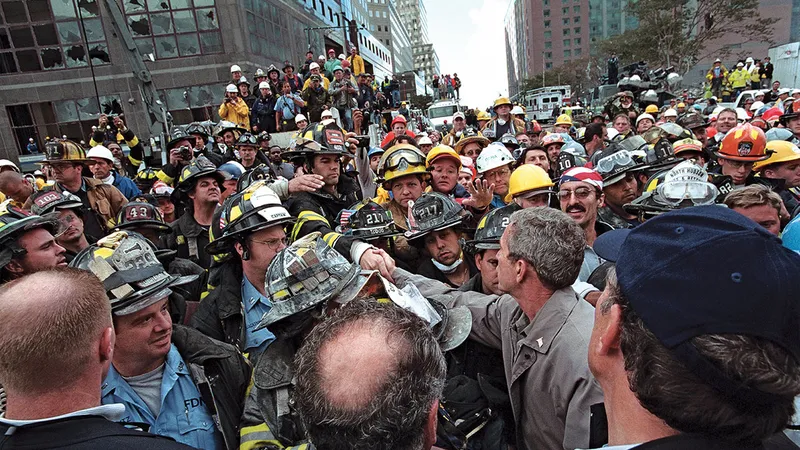 Bush salută pompierii, poliția și salvatorii în timp ce se deplasează prin ce a mai rămas din WTC, la trei zile după atacuri.