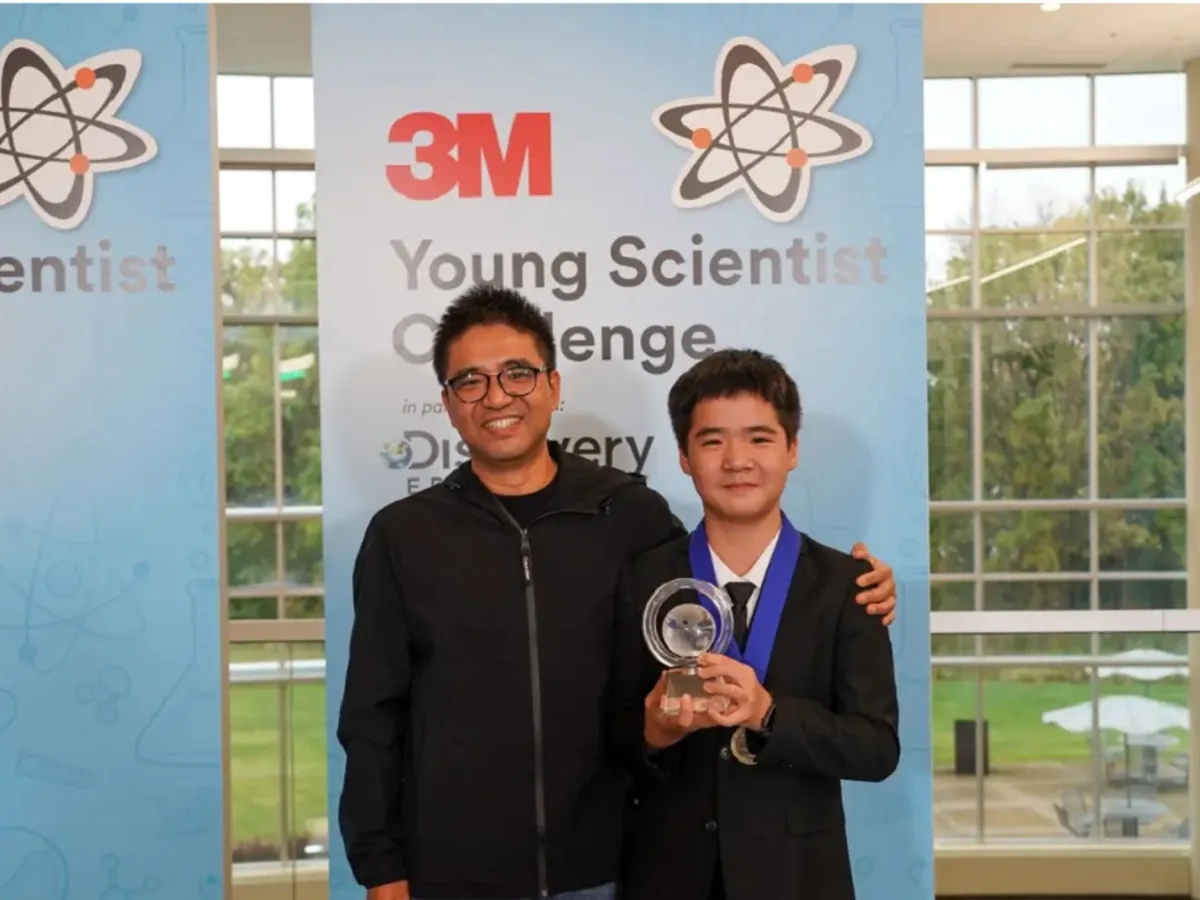 Kevin Tang ține trofeul premiului întâi, în timp ce stă alături de tatăl său. - Foto: Business Insider