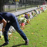 Un localnic din Christchurch depune flori în fața unui memorial amplasat în oraș