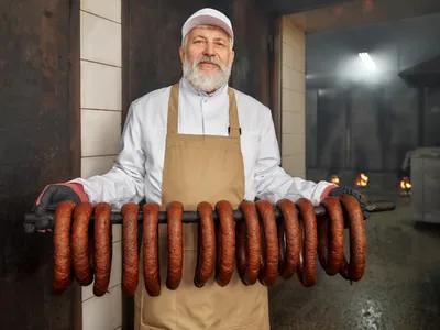 Bărbat care afumă cârnații - Foto: Freepik (Imagine cu rol ilustrativ)