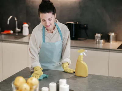 Persoană care sterge blatul din bucătărie - Foto: Freepik (Imagine cu rol ilustrativ)