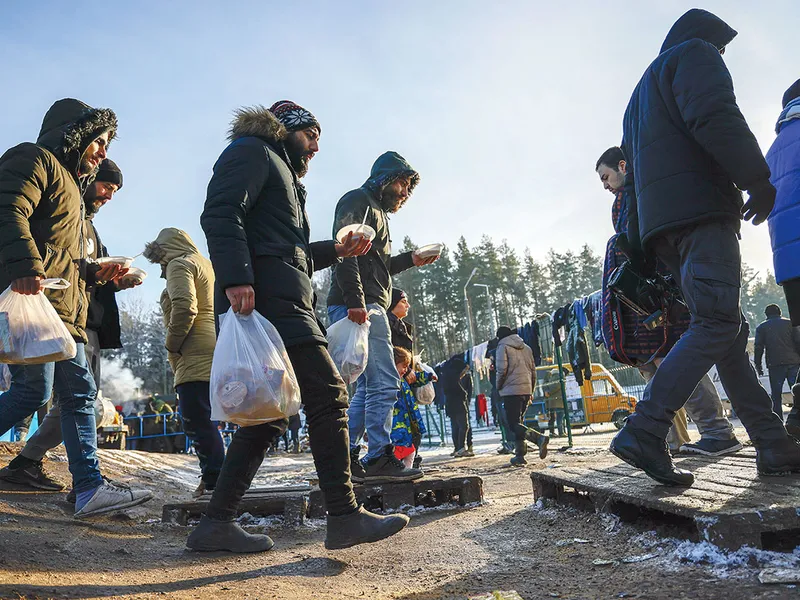 CRIZĂ Migranții primesc hrană în timp ce așteaptă o soluție umanitară pentru ei, într-o zonă închisă de la granița Belarus-Polonia din Grodno, Belarus, pe 1 decembrie 2021 - Foto: Getty Images