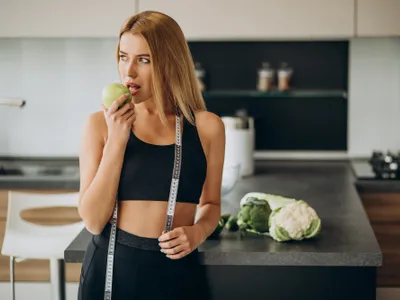 O femeie mănâncă un măr - Foto: Freepik (rol ilustrativ)