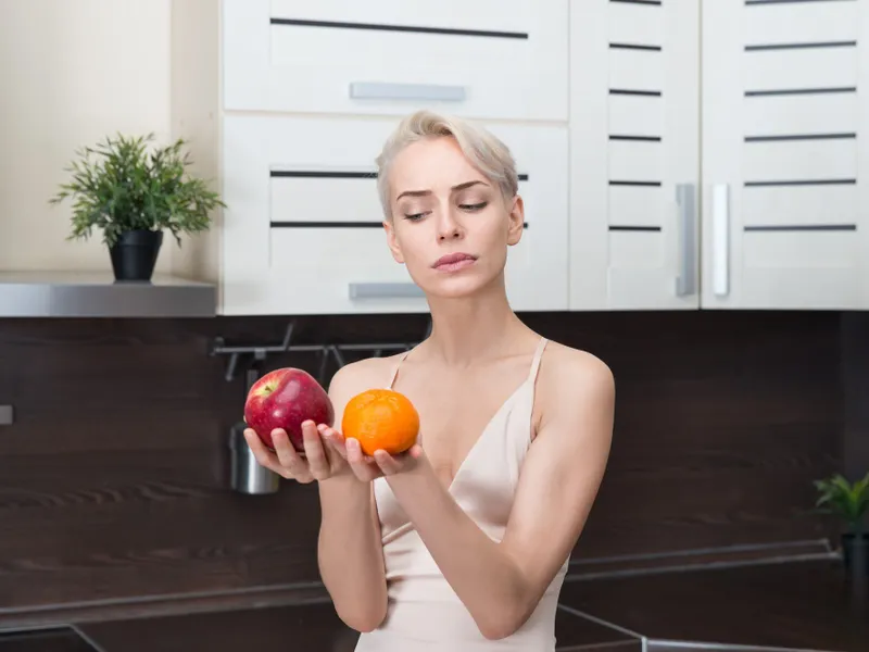 Femeie frumoasă care ține în mână fructe - Foto: Freepik