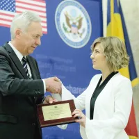 Elena Calistru, premiată, în mai 2018, de ambasadorul SUA, Hans Klemm, pentru curaj